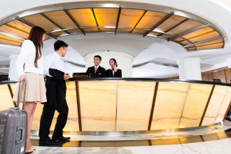 Asian Chinese woman and man arriving at front desk or reception