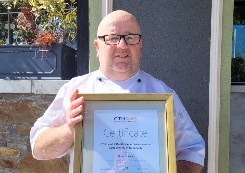 Odran Lucey, executive chef holding his framed Level 4 Certificate in Environmental Sustainability in Hospitality.